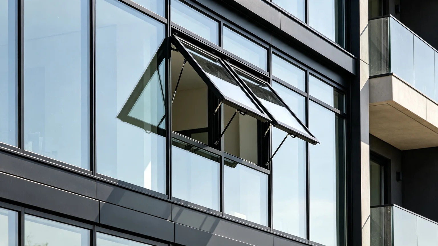 Aluminum awning window combined with fixed glass panels forming neat continuous facade system — Starveil Build